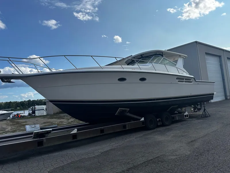 The Image of 1999 Tiara Yachts 43 Open on trailer, parked outdoors under a clear sky. - 1