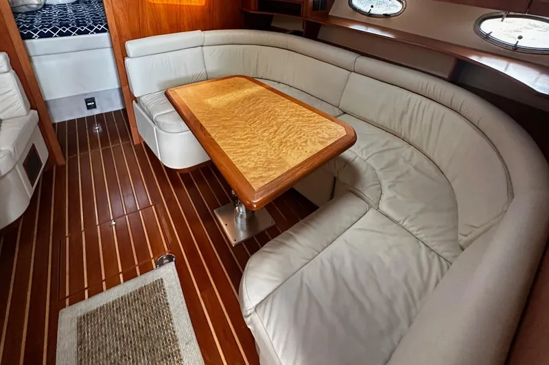 Slide: The Image of Luxurious interior of 1999 Tiara Yachts 43 Open with curved seating and wooden table. - 18