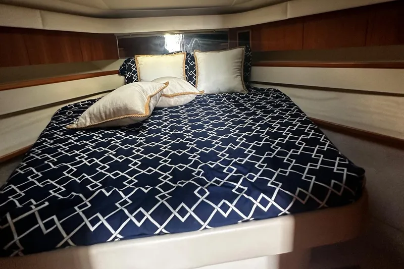 Slide: The Image of Cozy cabin interior of 1999 Tiara Yachts 43 Open with patterned bedding and pillows. - 20