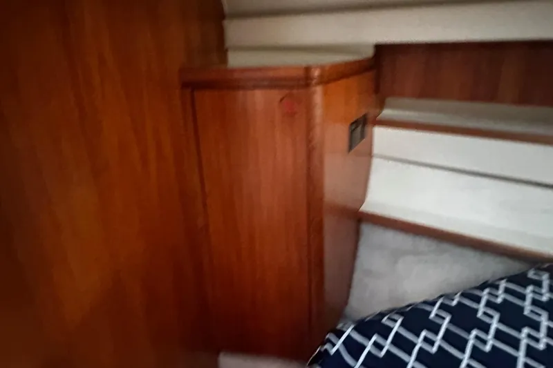 Slide: The Image of Interior of 1999 Tiara Yachts 43 Open, featuring wooden cabinetry and stairs. - 23