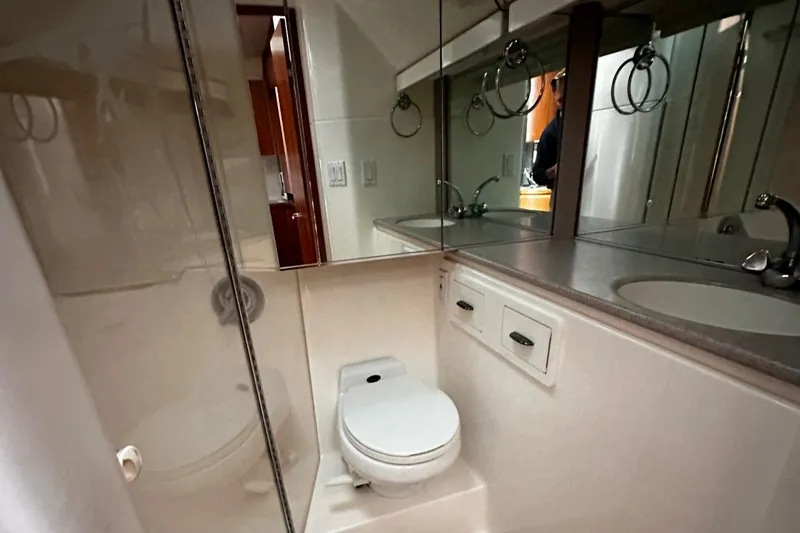 Slide: The Image of Bathroom interior of 1999 Tiara Yachts 43 Open, featuring toilet and mirrored cabinets. - 26