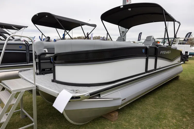 Slide: The Image of 2025 Premier 230 Solaris RF pontoon boat displayed on grass with canopy. - 2