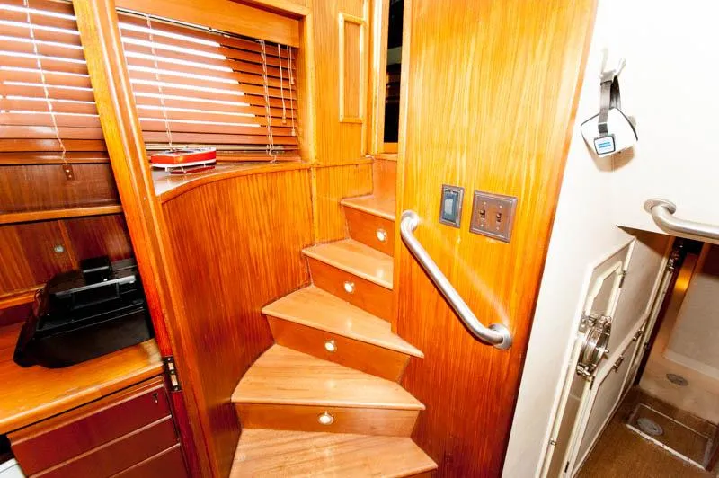 Slide: The Image of Interior wooden staircase on 1980 Hatteras 58 Motor Yacht, featuring elegant design and craftsmanship. - 11