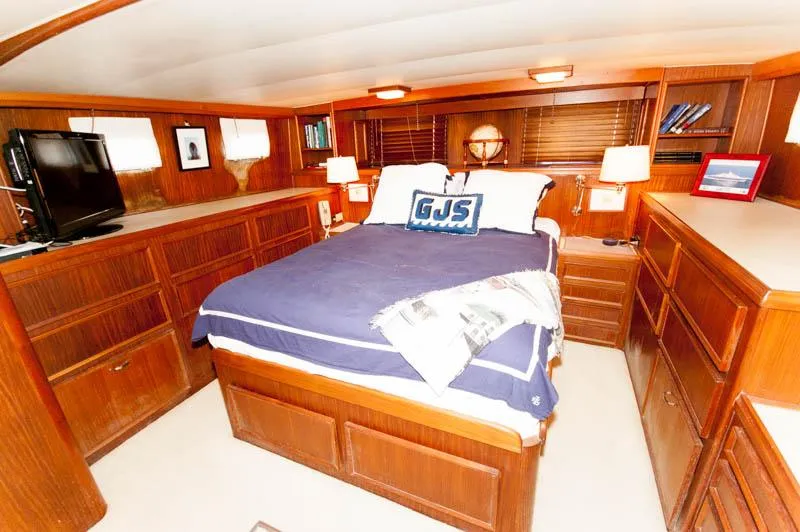 Slide: The Image of Luxurious cabin interior of 1980 Hatteras 58 Motor Yacht with wood furnishings and cozy bedding. - 18