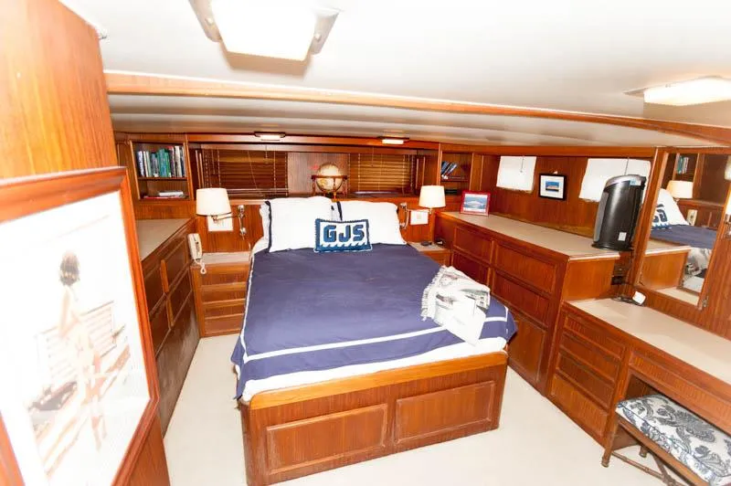 Slide: The Image of 1980 Hatteras 58 Motor Yacht bedroom with wood paneling, double bed, and built-in storage. - 19
