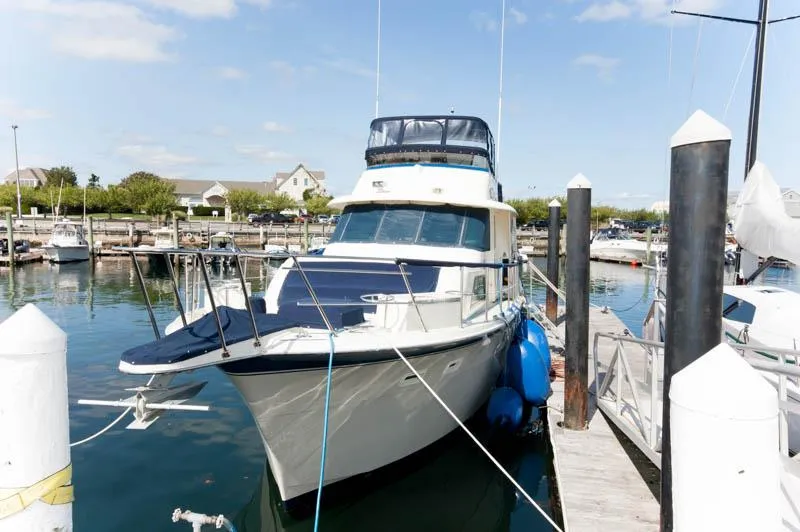 Slide: The Image of 1980 Hatteras 58 Motor Yacht docked in a sunny marina. - 2