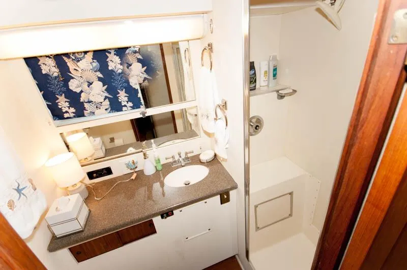 Slide: The Image of 1980 Hatteras 58 Motor Yacht bathroom with sink, shower, and floral curtains. - 20