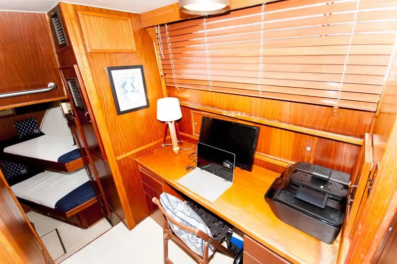 Slide: The Image of 1980 Hatteras 58 Motor Yacht interior with wooden desk, laptop, printer, and bunk beds. - 22