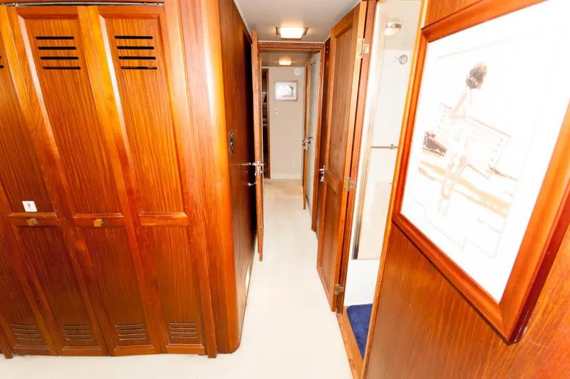 Slide: The Image of Interior hallway of 1980 Hatteras 58 Motor Yacht with wooden paneling and artwork. - 24