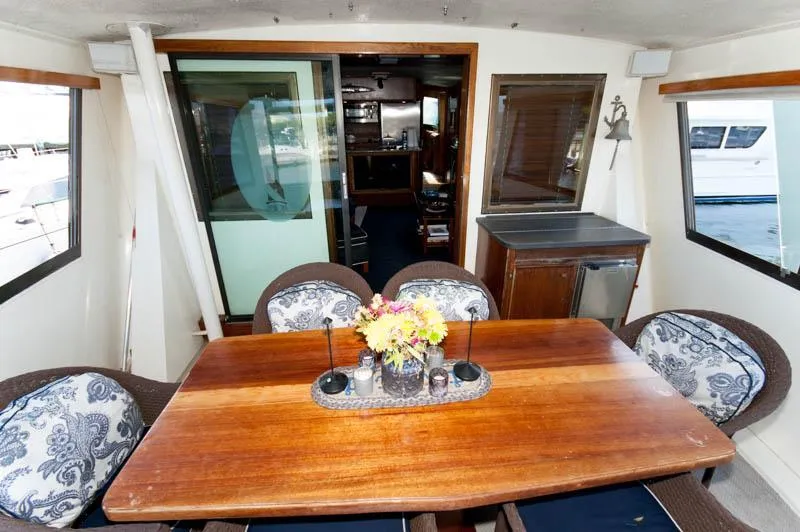 Slide: The Image of 1980 Hatteras 58 Motor Yacht interior with dining table and floral centerpiece. - 34