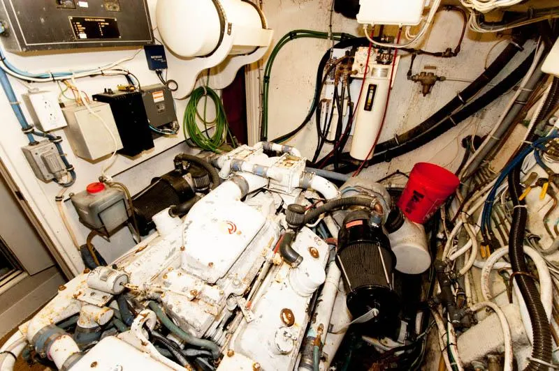 Slide: The Image of Engine room of a 1980 Hatteras 58 Motor Yacht, featuring complex machinery and wiring. - 37