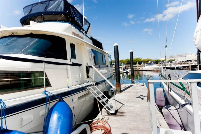 Slide: The Image of 1980 Hatteras 58 Motor Yacht docked at marina under clear blue sky. - 5