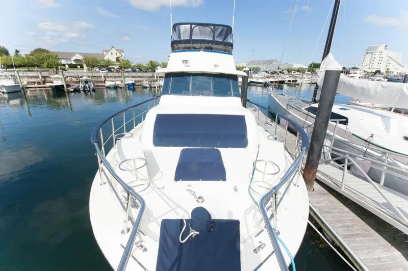 Slide: The Image of 1980 Hatteras 58 Motor Yacht docked at marina under clear blue sky. - 6