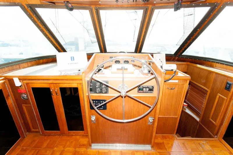 Slide: The Image of 1980 Hatteras 58 Motor Yacht helm with wooden steering wheel and navigation controls. - 7