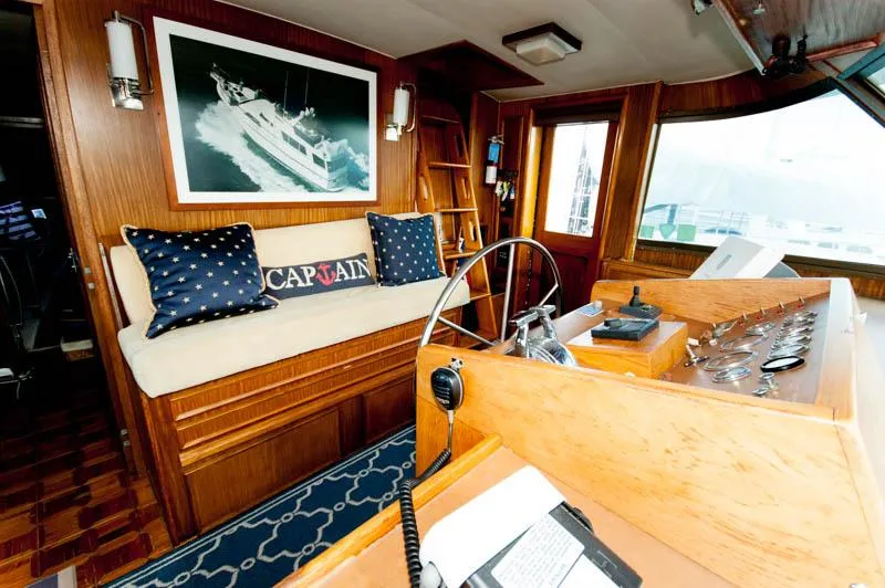 Slide: The Image of 1980 Hatteras 58 Motor Yacht interior with helm, seating, and nautical decor. - 8