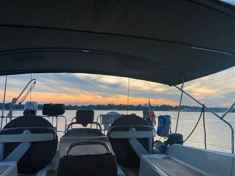 Slide: The Image of Jeanneau 58 sailboat deck at sunset, 2016 model, with scenic waterfront view. - 13