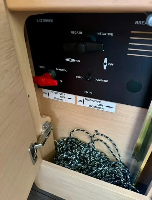 Slide: The Image of Electrical panel inside 2016 Jeanneau 58 yacht with battery controls and storage compartment. - 17