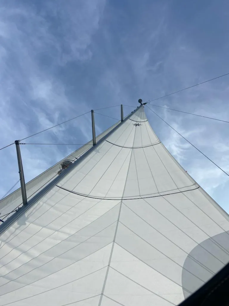 Slide: The Image of Sailing yacht Jeanneau 58, 2016 model, with sails unfurled against a clear blue sky. - 3