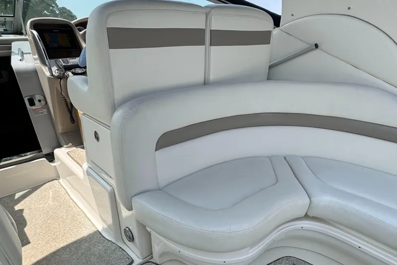 Slide: The Image of Interior seating of 2004 Sea Ray 320 Sundancer boat, featuring white and gray upholstery. - 10