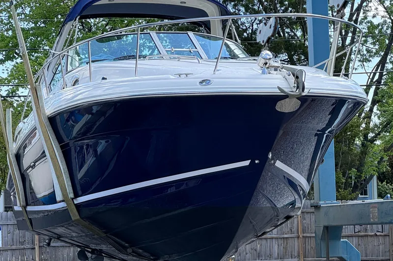 Slide: The Image of 2004 Sea Ray 320 Sundancer boat on lift, blue hull, docked outdoors. - 2