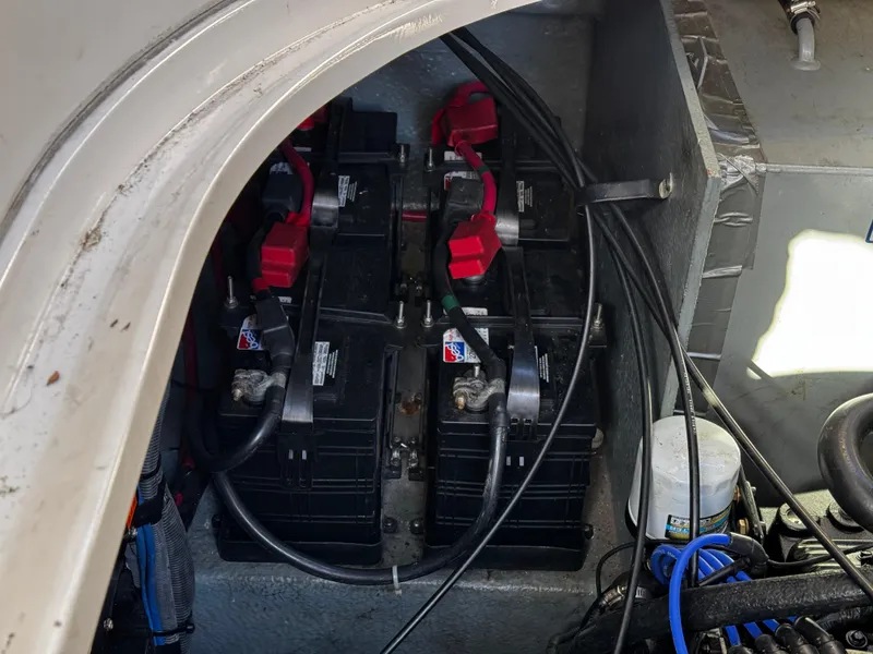 Slide: The Image of 2004 Sea Ray 320 Sundancer boat battery compartment with multiple batteries and cables. - 23
