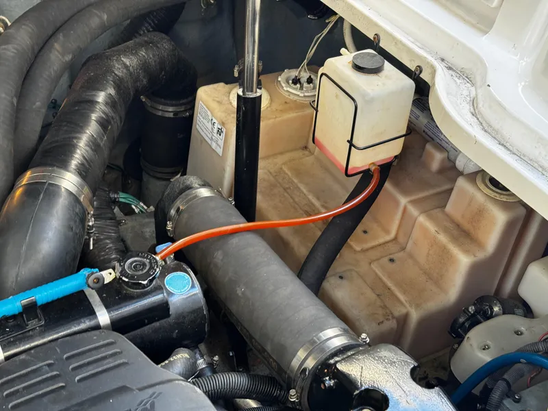 Slide: The Image of Engine compartment of a 2004 Sea Ray 320 Sundancer boat, showing hoses and components. - 25