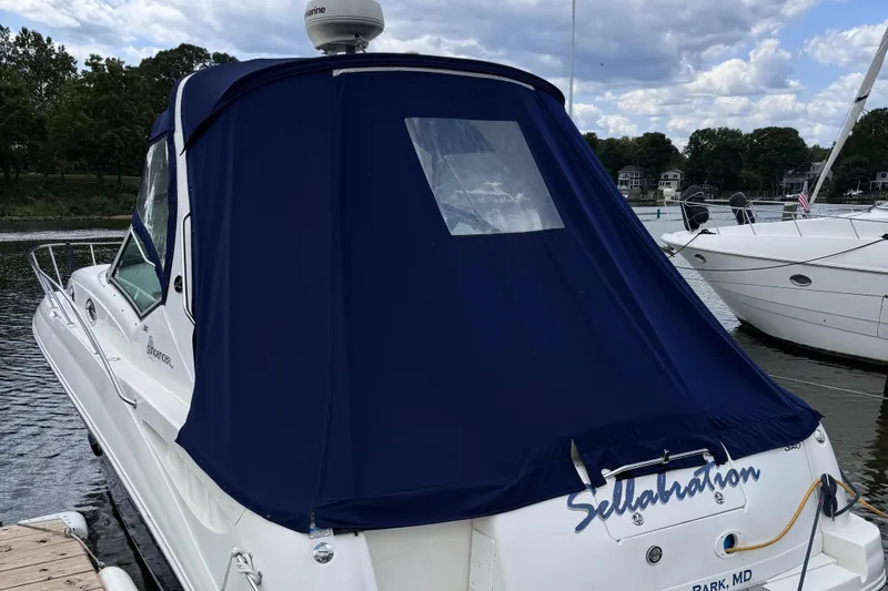 Slide: The Image of 2004 Sea Ray 320 Sundancer with blue canvas cover docked at marina. - 4