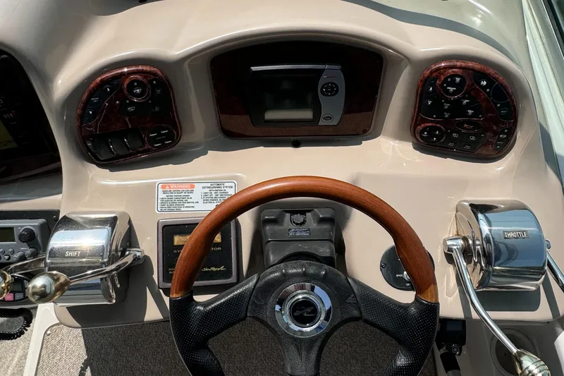 Slide: The Image of Dashboard of a 2004 Sea Ray 320 Sundancer boat with steering wheel and controls. - 8