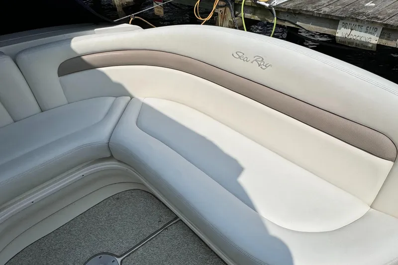 Slide: The Image of Interior seating of 2004 Sea Ray 320 Sundancer boat, featuring white and beige upholstery. - 9