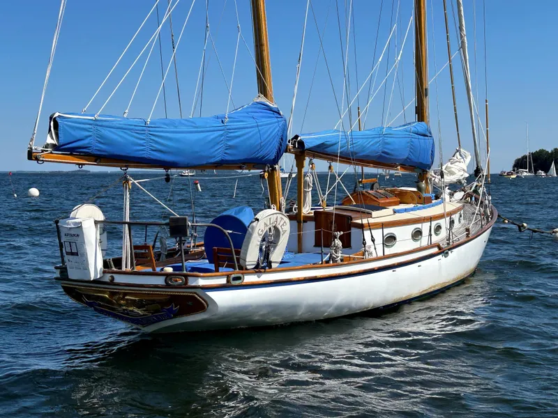 Slide: The Image of 1985 Herreshoff Nereia Molly's Cove 38' sailboat with FRP hull, anchored on calm water. - 21