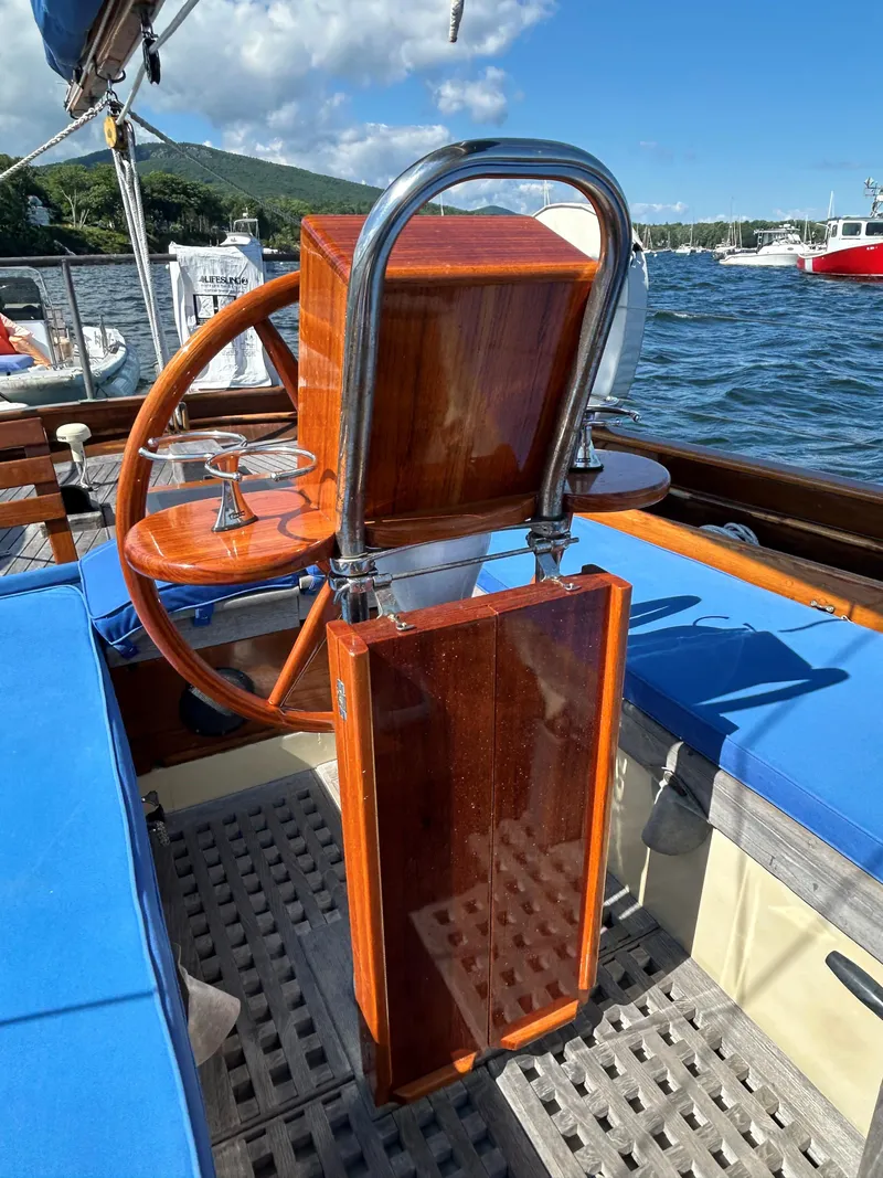Slide: The Image of 1985 Herreshoff Nereia Molly's Cove 38' sailboat with FRP hull, wooden helm, and blue seating. - 22