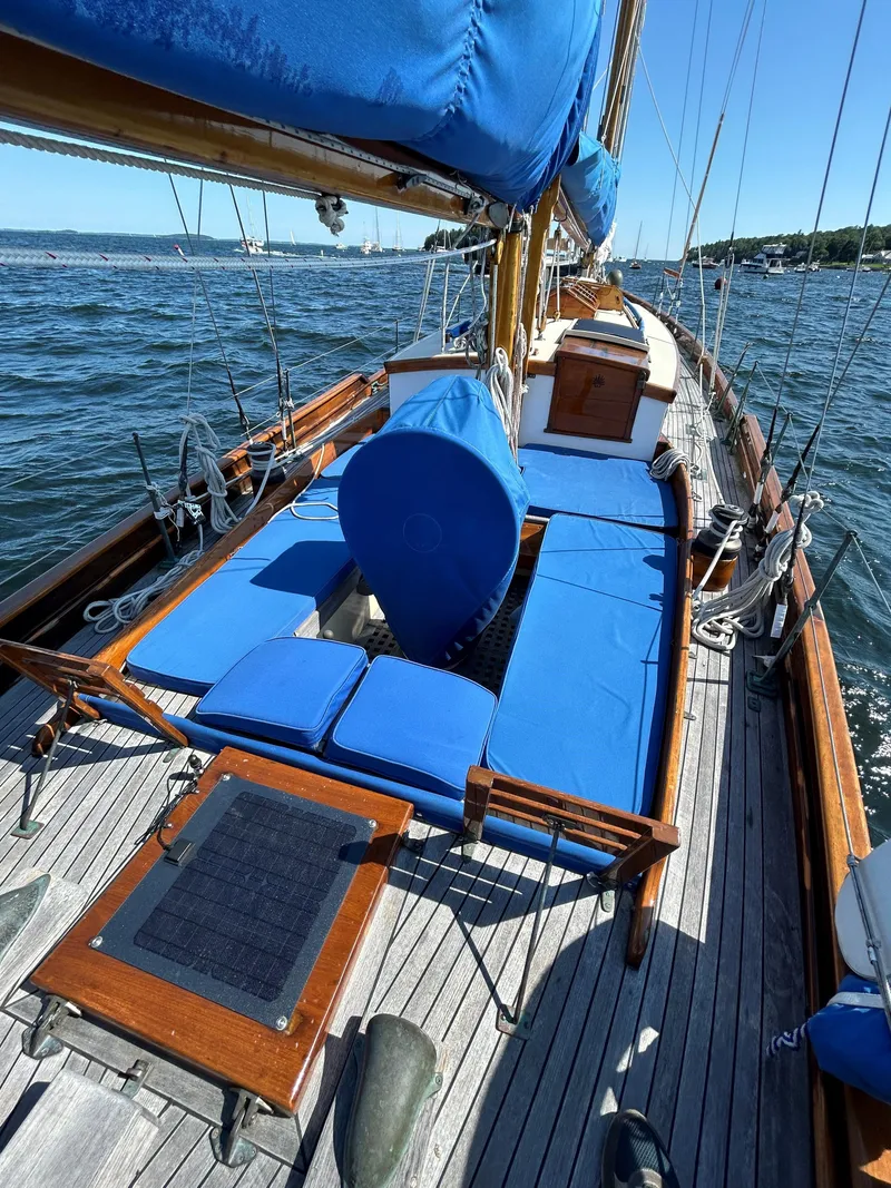 Slide: The Image of 1985 Herreshoff Nereia Molly's Cove 38' sailboat with blue deck cushions and FRP hull. - 27