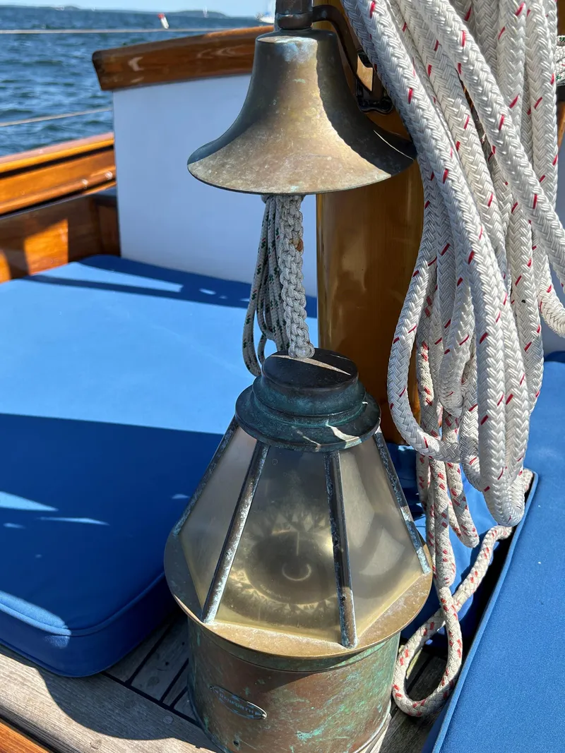 Slide: The Image of Vintage Herreshoff sailboat details with bell, lantern, and ropes on deck. - 28