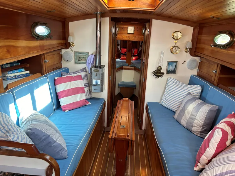 Slide: The Image of 1985 Herreshoff Nereia Molly's Cove 38' yacht interior with blue cushions and wooden accents. - 4