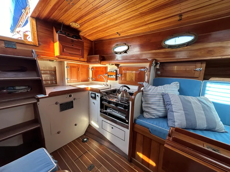 Slide: The Image of Interior of 1985 Herreshoff Nereia Molly's Cove 38' with FRP hull, featuring wood finish and seating. - 42