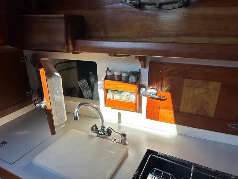 Slide: The Image of 1985 Herreshoff Nereia Molly's Cove 38' yacht kitchen with wooden cabinets and sink. - 43