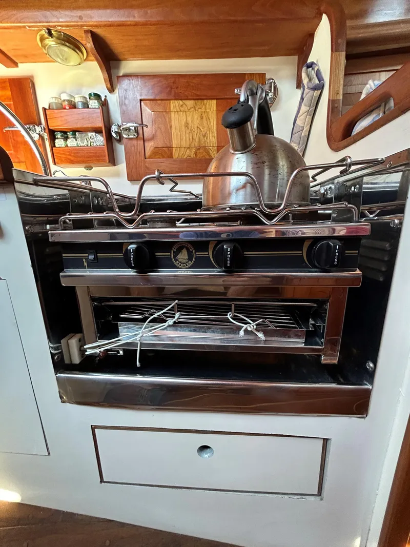 Slide: The Image of 1985 Herreshoff Nereia Molly's Cove yacht kitchen with stove and kettle. - 44