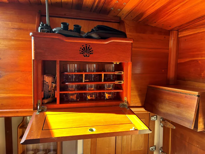 Slide: The Image of Wooden interior of 1985 Herreshoff Nereia Molly's Cove yacht with glass storage cabinet. - 46