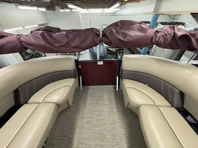 Slide: The Image of 2022 Sylvan Mirage X X3 pontoon boat interior with beige seating and maroon cover. - 11