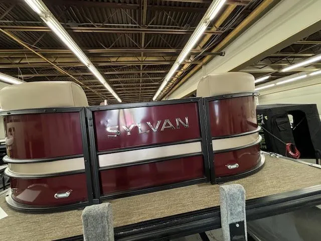 Slide: The Image of 2022 Sylvan Mirage X X3 pontoon boat in showroom, maroon and beige design. - 18