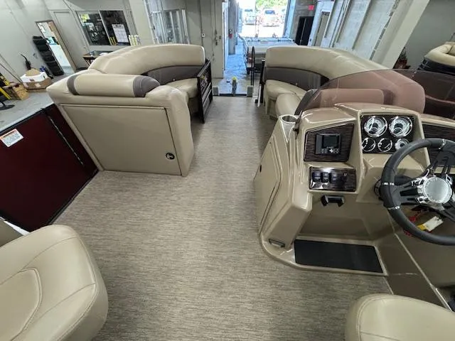 Slide: The Image of 2022 Sylvan Mirage X X3 pontoon boat interior with beige seating and modern dashboard. - 6