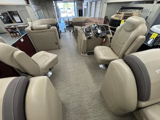 Slide: The Image of 2022 Sylvan Mirage X X3 pontoon boat interior with beige seating and modern dashboard. - 9
