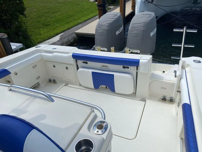 Slide: The Image of 2004 Hydra-Sports Vector 3300 CC boat interior with dual Suzuki engines, docked by grassy area. - 10