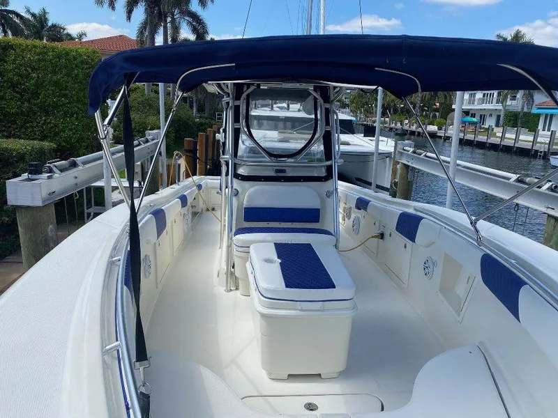 Slide: The Image of 2004 Hydra-Sports Vector 3300 CC boat with blue canopy, docked in a marina. - 12