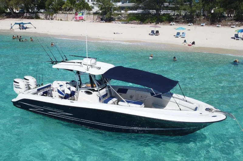 Slide: The Image of 2004 Hydra-Sports Vector 3300 CC boat in clear turquoise water near a sandy beach. - 2