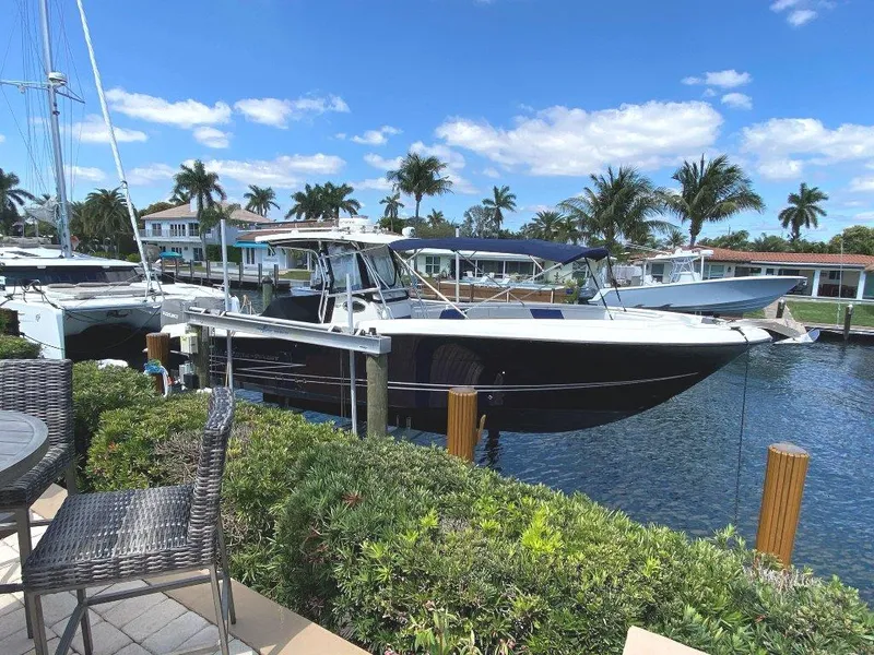 Slide: The Image of 2004 Hydra-Sports Vector 3300 CC docked by waterfront homes, surrounded by palm trees. - 4