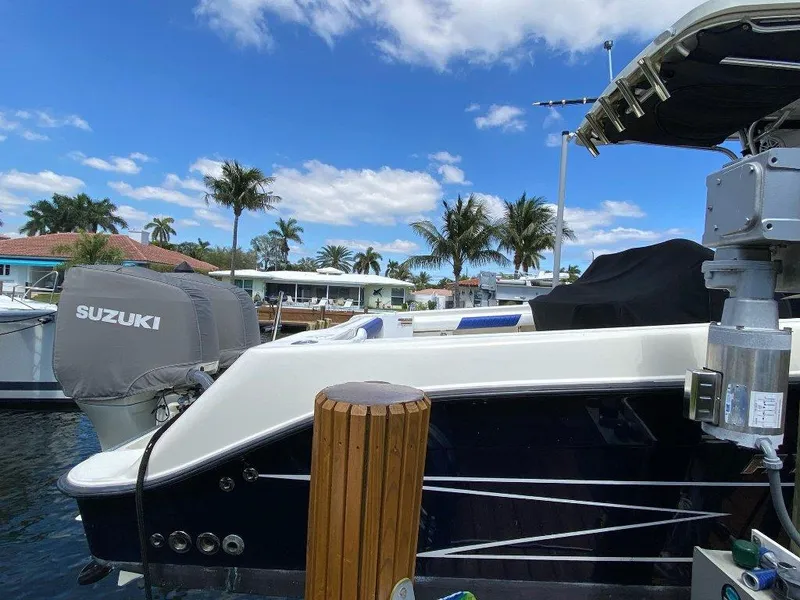 Slide: The Image of 2004 Hydra-Sports Vector 3300 CC boat docked, featuring Suzuki outboard motor, under blue sky. - 6