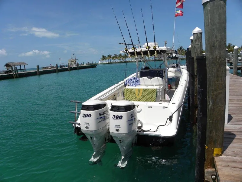 Slide: The Image of 2004 Hydra-Sports Vector 3300 CC boat docked with dual Suzuki engines, clear blue water. - 7