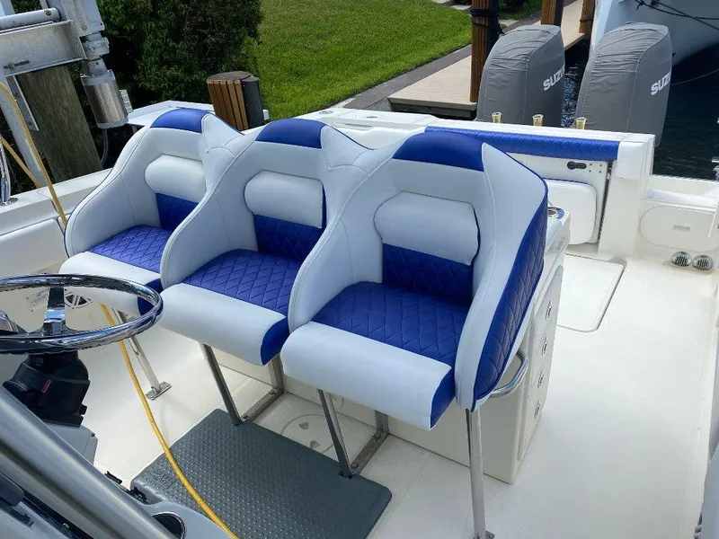 Slide: The Image of 2004 Hydra-Sports Vector 3300 CC boat with blue and white seating, docked near lush greenery. - 9