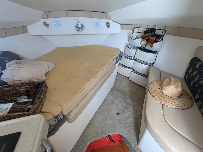Slide: The Image of Interior cabin of 2004 Larson Cabrio 260 boat with bed and seating area. - 15
